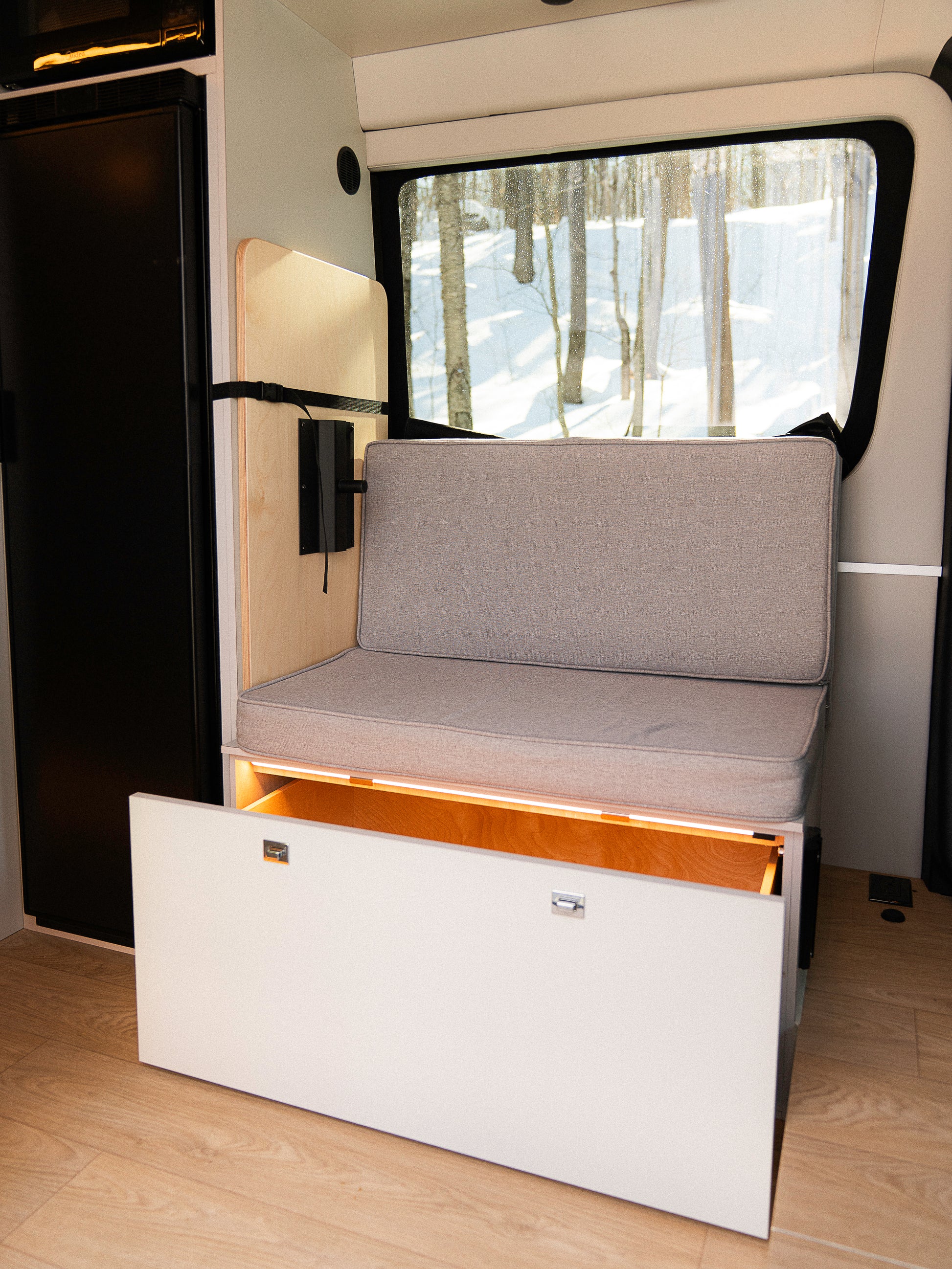 Banc van New West avec coffre de rangement ouvert sous le coussin en espace garage