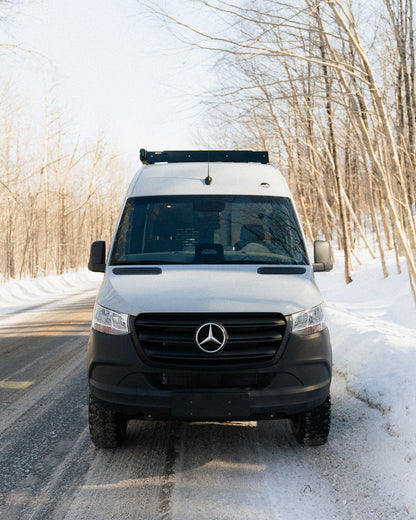 Van aménagé Mercedes Sprinter New West vue avant sur route enneigée au Québec