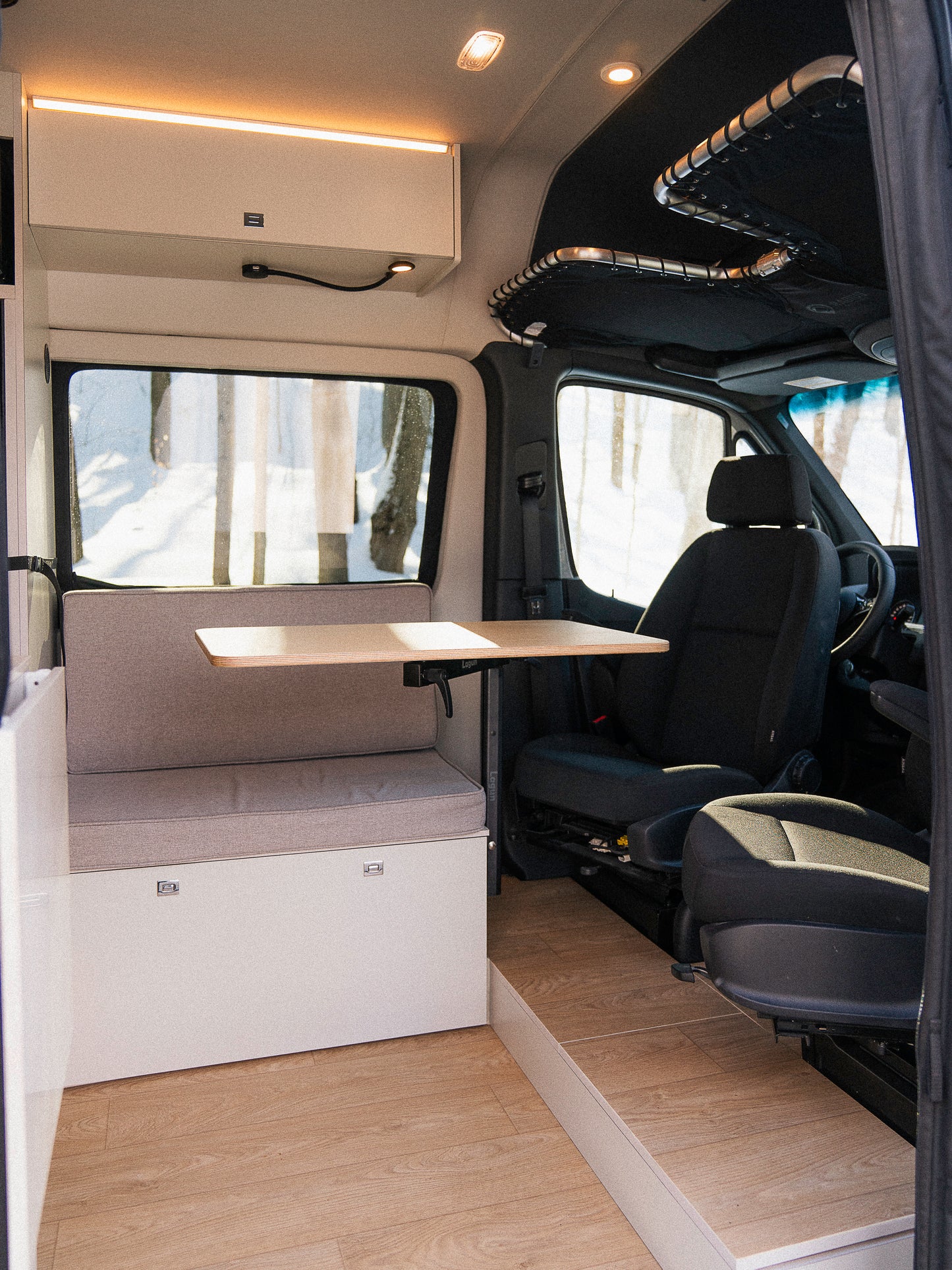 Intérieur van aménagé New West avec table déployée et siège passager pivotant